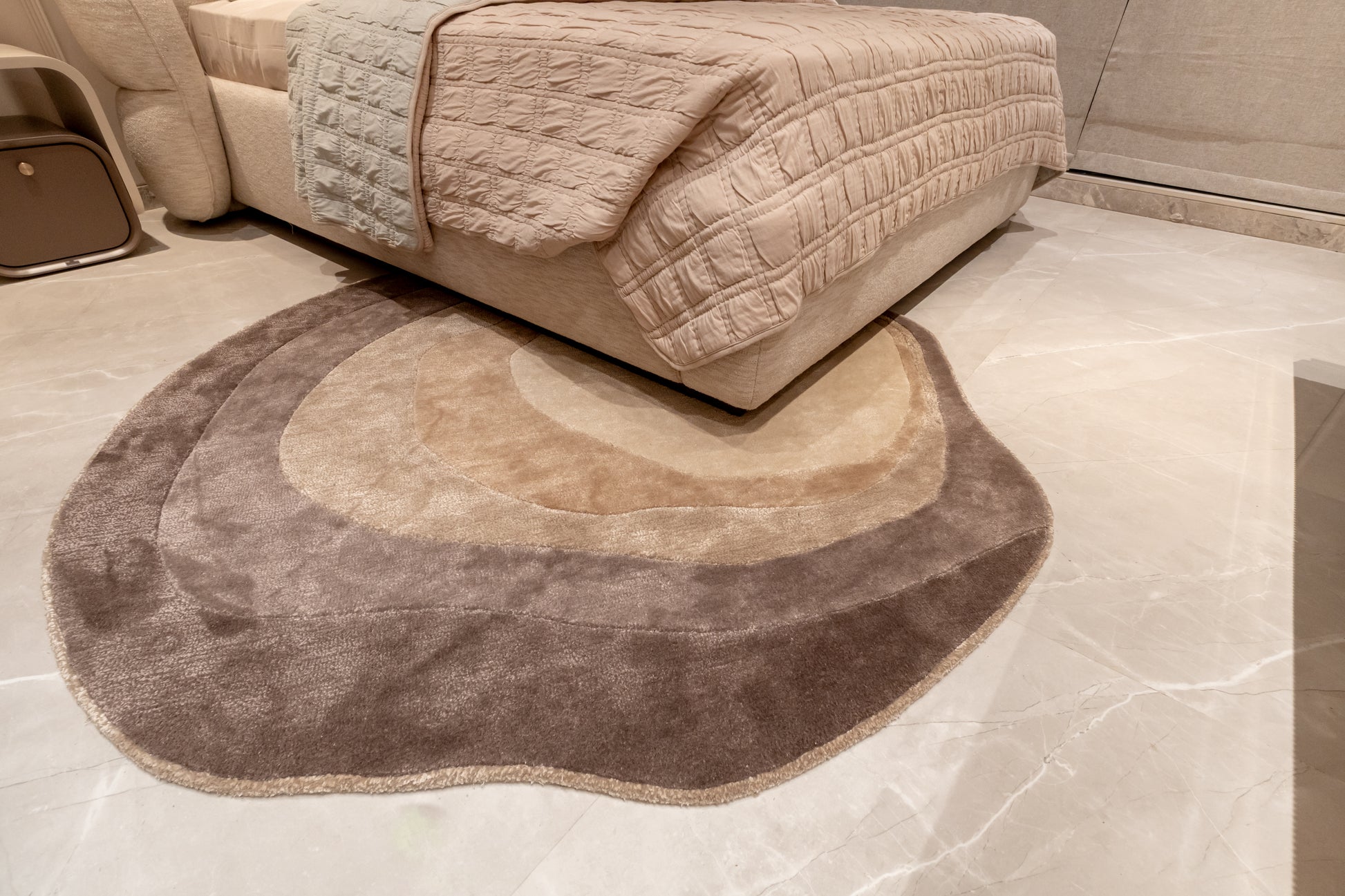 Beige textured sofa with a matching rug on a tiled floor
