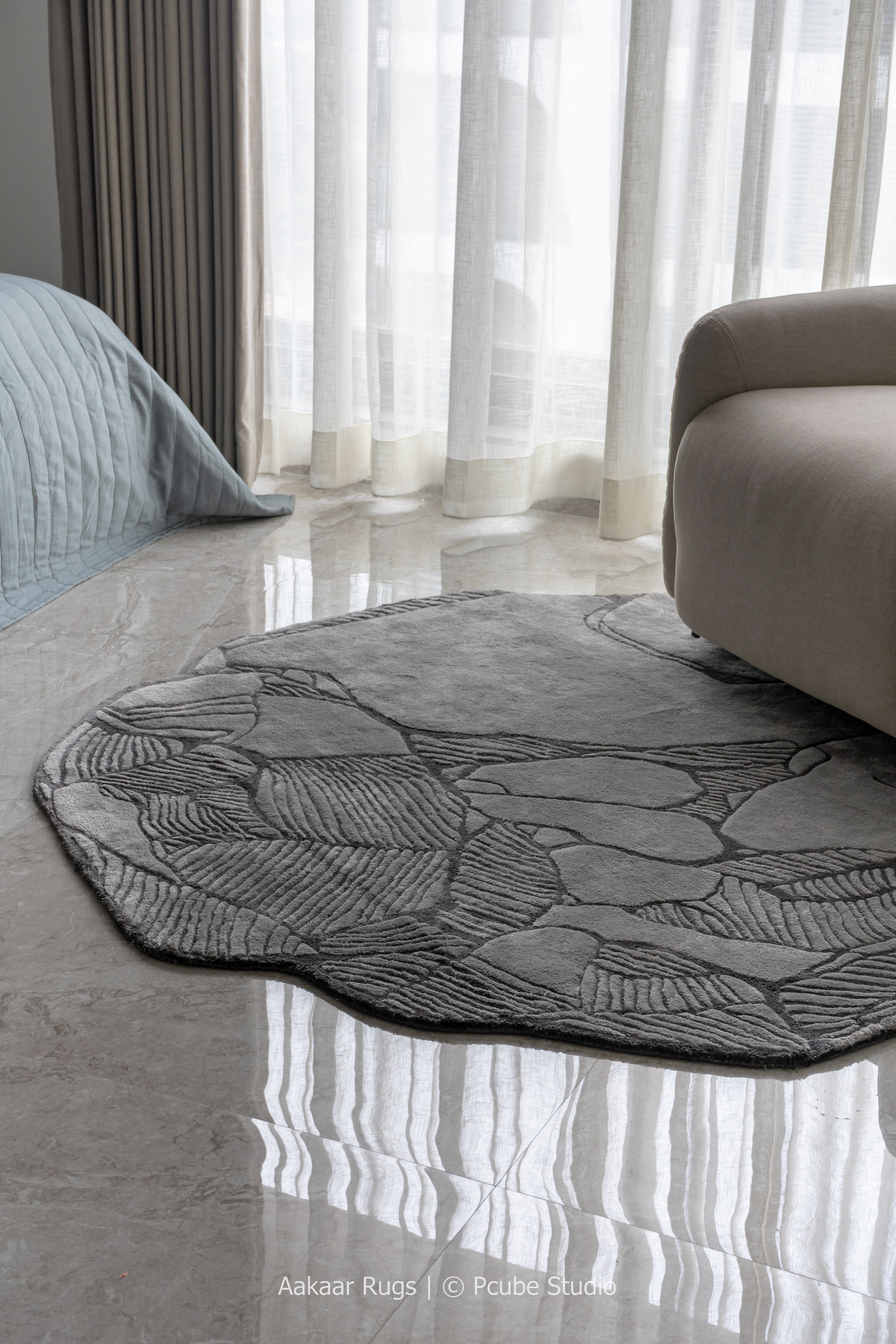 Round leaf-patterned rug on a marble floor with a modern interior setting.