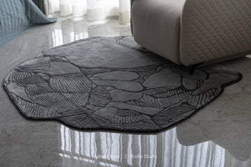 Round textured rug on a polished floor with a sofa in the background