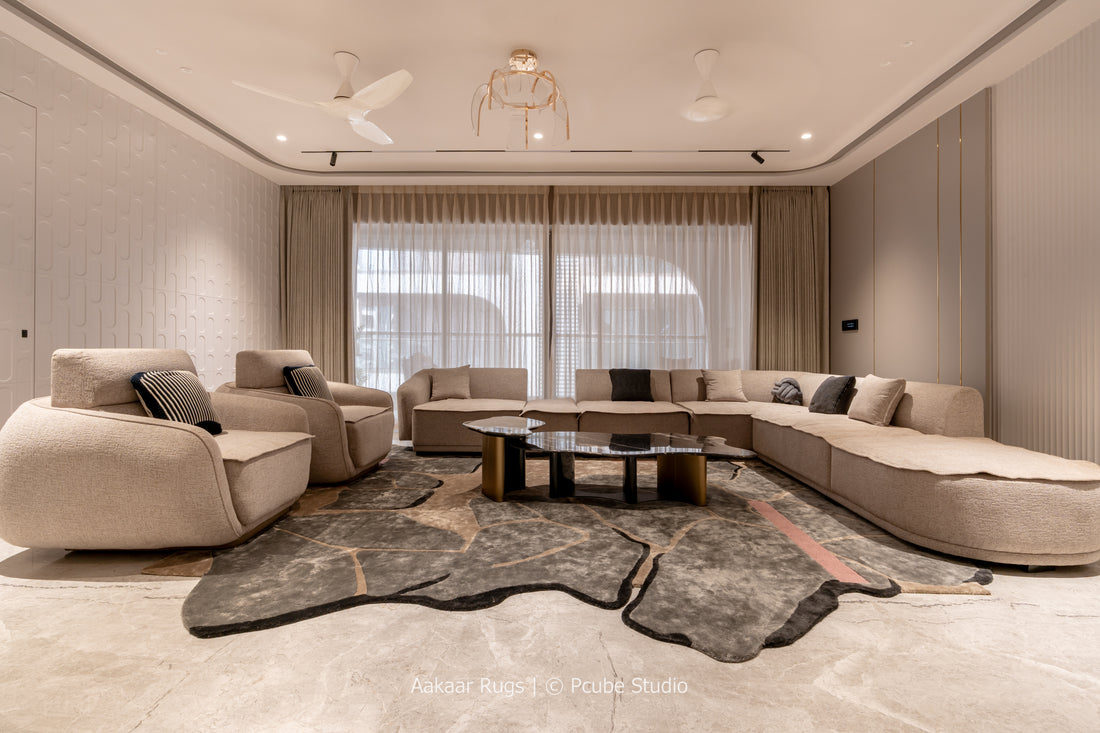 Modern living room with beige sectional sofa, coffee table, and decorative rug.
